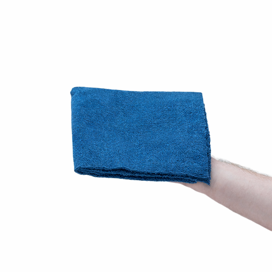 Blue towel held by a hand on a white background